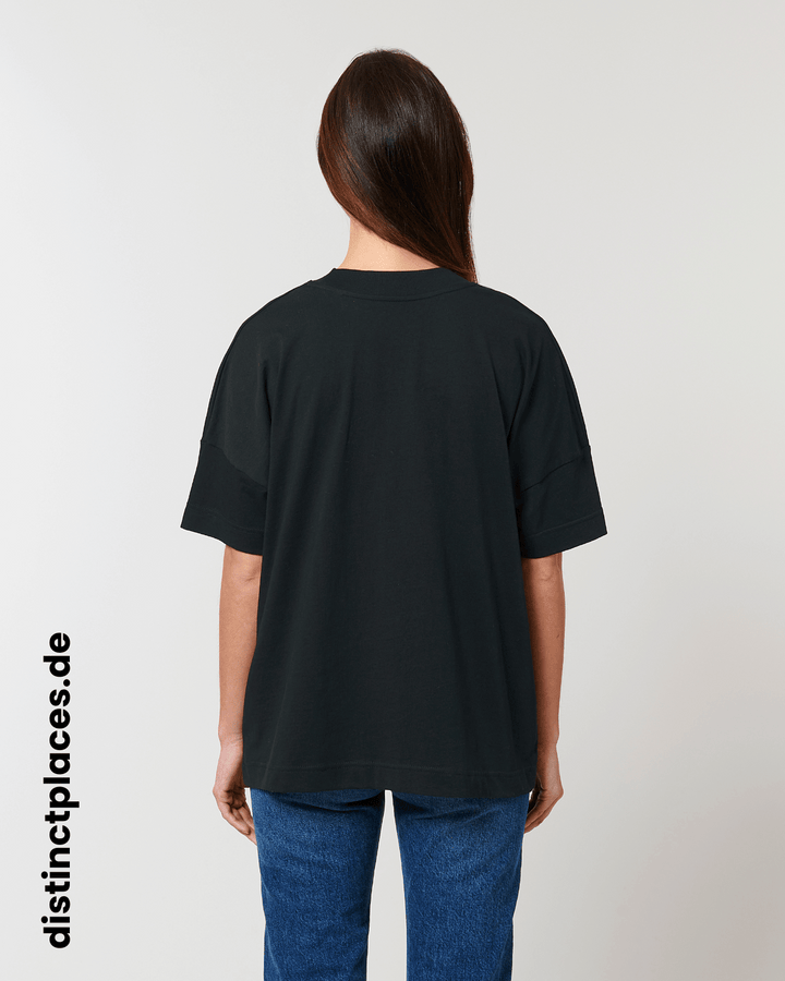 Frau von hinten trägt schwarzes fairtrade, vegan und bio-baumwoll Oversized T-Shirt mit einem minimalistischem weißen Logo, beziehungsweise Wappen für Ludwigshafen