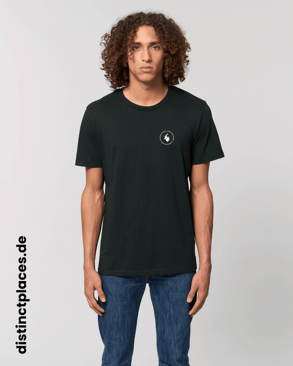 Mann von vorne trägt schwarzes fairtrade, vegan und bio-baumwoll T-Shirt mit einem minimalistischem weißen Logo, beziehungsweise Wappen und Schriftzug für Baden-Wuerttemberg