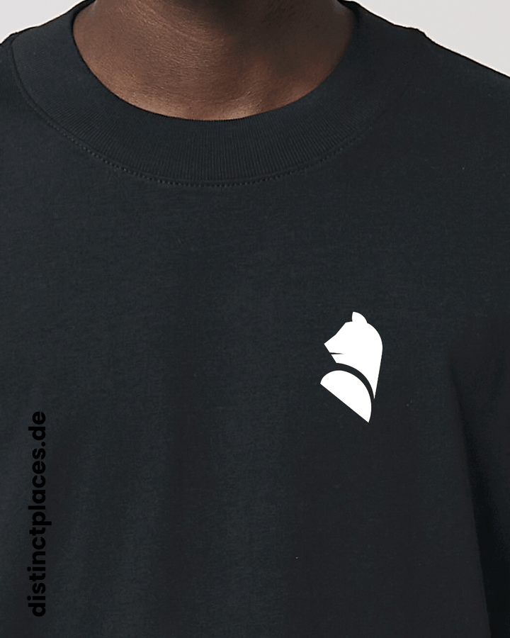 Detailansicht schwarzes fairtrade, vegan und bio-baumwoll Oversized T-Shirt von vorne mit einem minimalistischem weißen Logo, beziehungsweise Wappen für Berlin