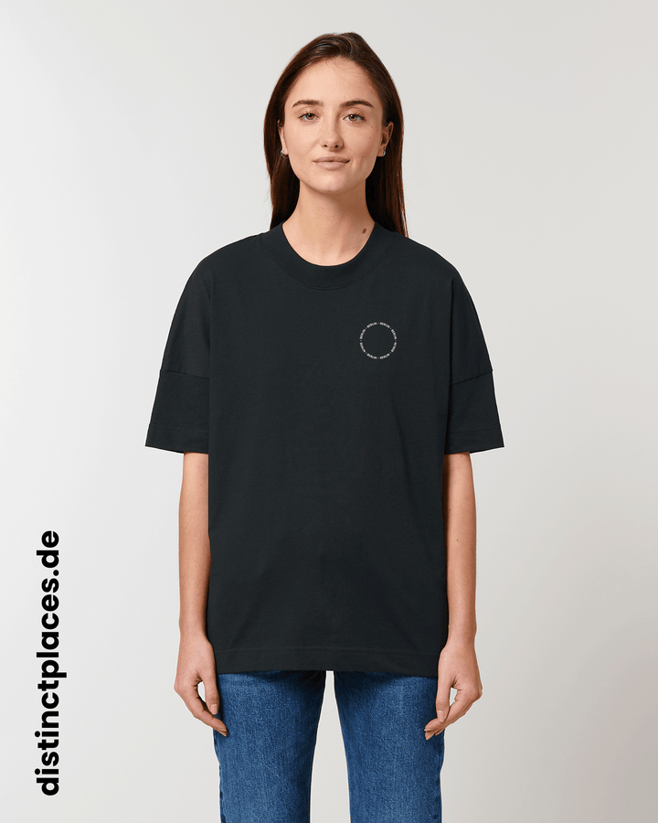 Frau von vorne trägt schwarzes fairtrade, vegan und bio-baumwoll T-Shirt mit einem minimalistischem weißen Logo, beziehungsweise Schriftzug für Berlin