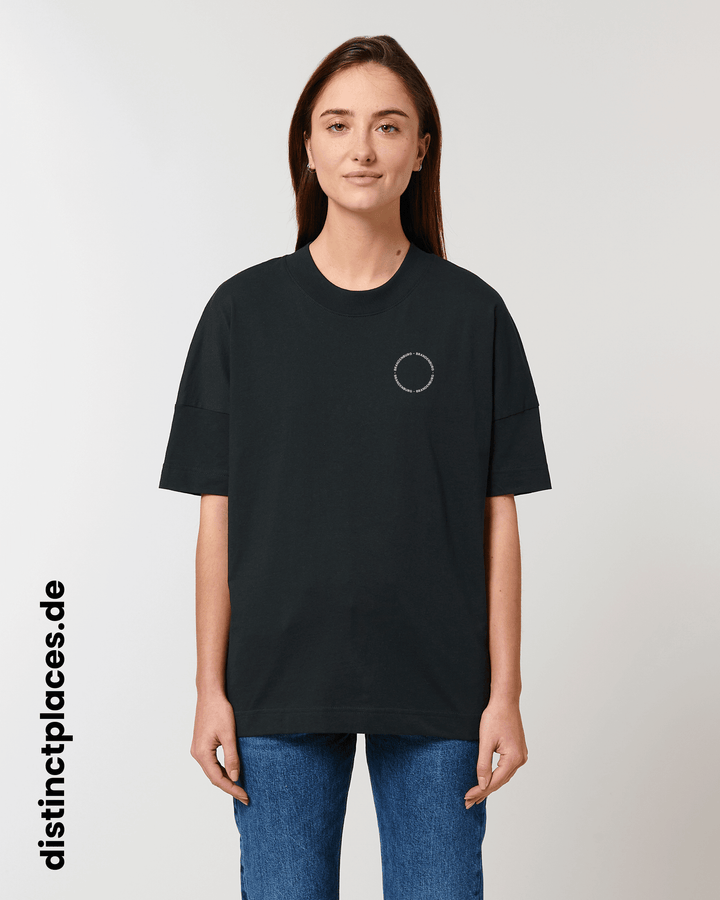 Frau von vorne trägt schwarzes fairtrade, vegan und bio-baumwoll T-Shirt mit einem minimalistischem weißen Logo, beziehungsweise Schriftzug für Brandenburg