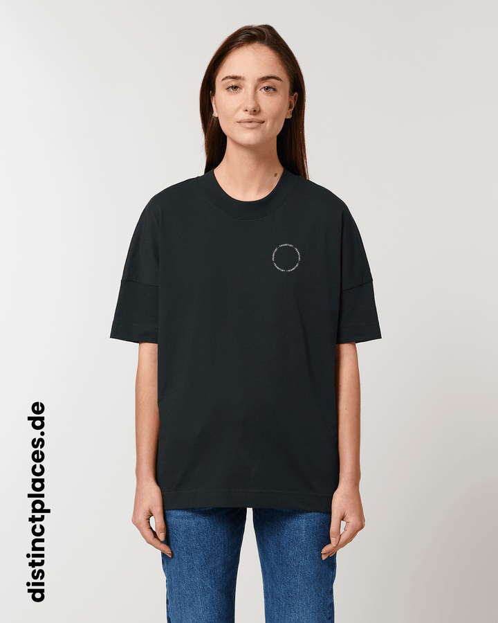 Frau von vorne trägt schwarzes fairtrade, vegan und bio-baumwoll T-Shirt mit einem minimalistischem weißen Logo, beziehungsweise Schriftzug für Frankfurt