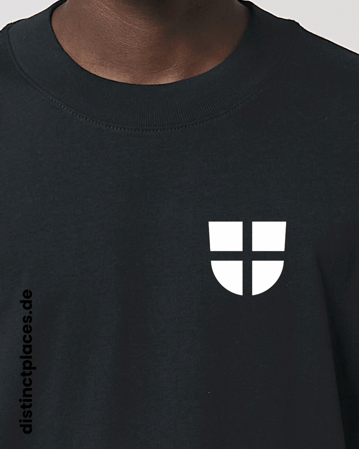 Detailansicht schwarzes fairtrade, vegan und bio-baumwoll Oversized T-Shirt von vorne mit einem minimalistischem weißen Logo, beziehungsweise Wappen für Freiburg