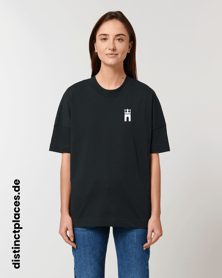 Frau von vorne trägt schwarzes fairtrade, vegan und bio-baumwoll T-Shirt mit einem minimalistischem weißen Logo, beziehungsweise Wappen für Hamburg