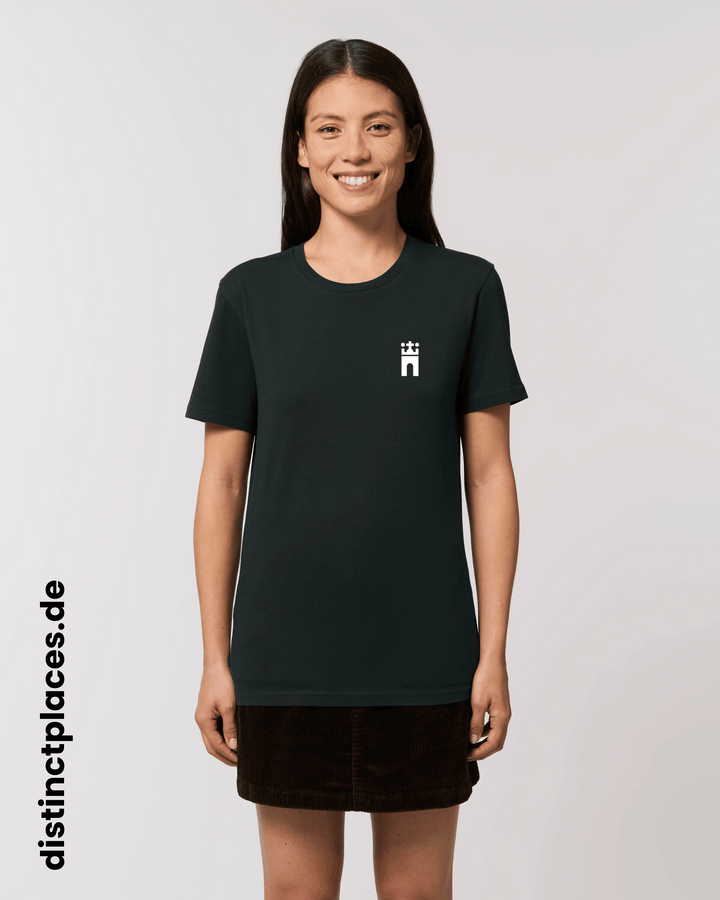 Frau von vorne trägt schwarzes fairtrade, vegan und bio-baumwoll T-Shirt mit einem minimalistischem weißen Logo, beziehungsweise Wappen für Hamburg