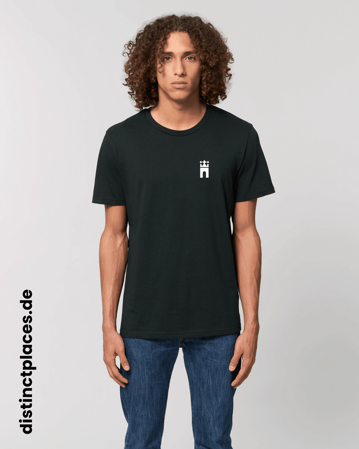 Mann von vorne trägt schwarzes fairtrade, vegan und bio-baumwoll T-Shirt mit einem minimalistischem weißen Logo, beziehungsweise Wappen für Hamburg