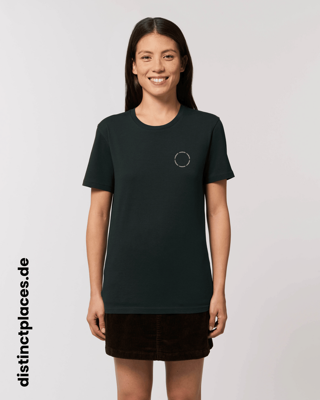 Frau von vorne trägt schwarzes fairtrade, vegan und bio-baumwoll T-Shirt mit einem minimalistischem weißen Logo, beziehungsweise Schriftzug für Hamburg