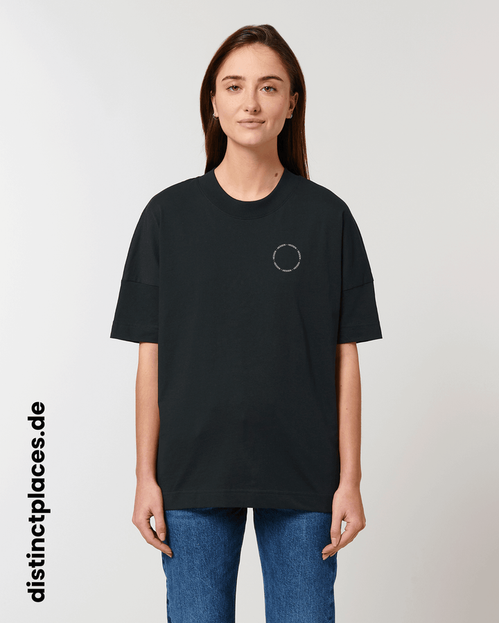 Frau von vorne trägt schwarzes fairtrade, vegan und bio-baumwoll T-Shirt mit einem minimalistischem weißen Logo, beziehungsweise Schriftzug für Hessen