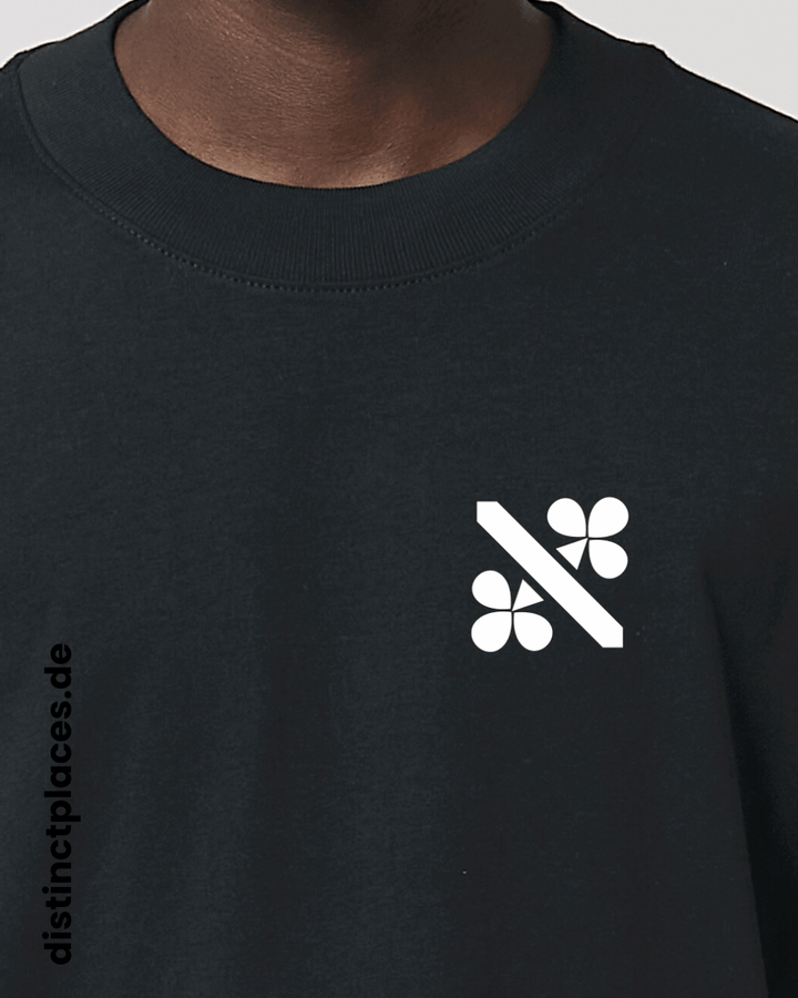 Detailansicht schwarzes fairtrade, vegan und bio-baumwoll Oversized T-Shirt von vorne mit einem minimalistischem weißen Logo, beziehungsweise Wappen für Kassel