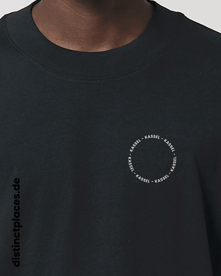 Detailansicht schwarzes fairtrade, vegan und bio-baumwoll Oversized T-Shirt von vorne mit einem minimalistischem weißen Logo, beziehungsweise Schriftzug für Kassel