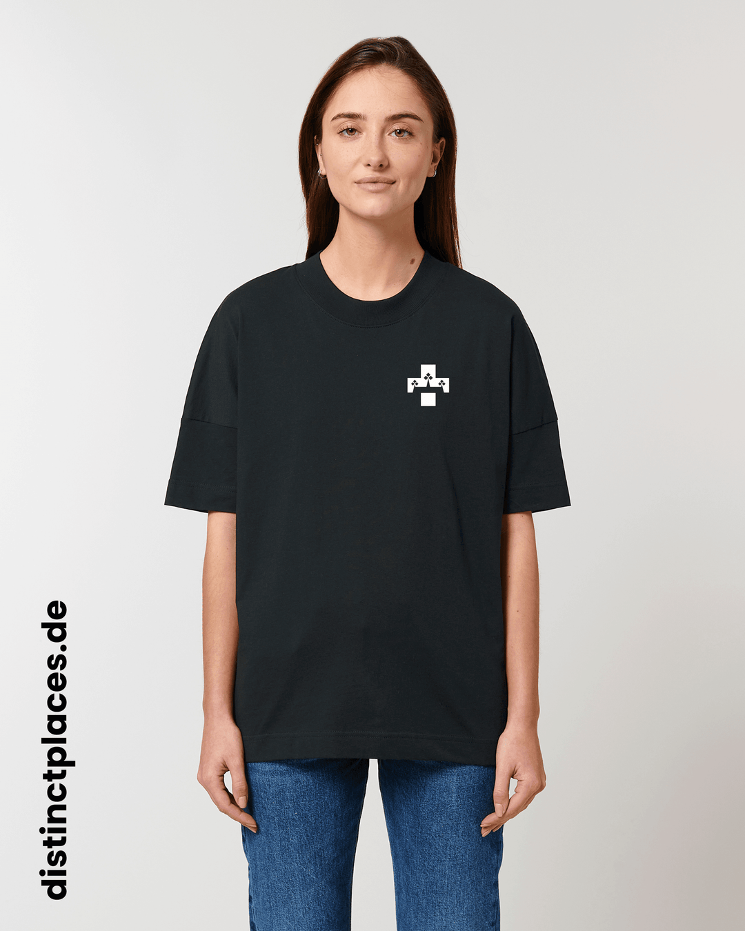 Frau von vorne trägt schwarzes fairtrade, vegan und bio-baumwoll T-Shirt mit einem minimalistischem weißen Logo, beziehungsweise Wappen für Koblenz