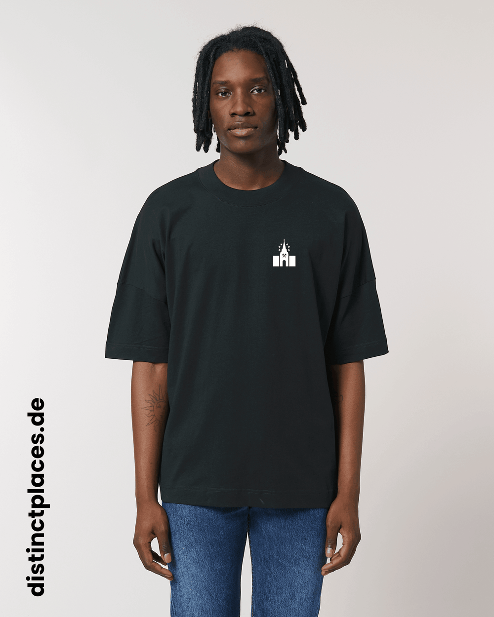 Mann von vorne trägt schwarzes fairtrade, vegan und bio-baumwoll T-Shirt mit einem minimalistischem weißen Logo, beziehungsweise Wappen für Neunkirchen