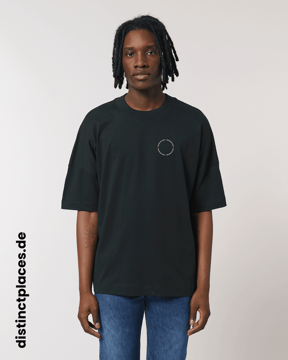 Mann von vorne trägt schwarzes fairtrade, vegan und bio-baumwoll T-Shirt mit einem minimalistischem weißen Logo, beziehungsweise Schriftzug für Neunkirchen