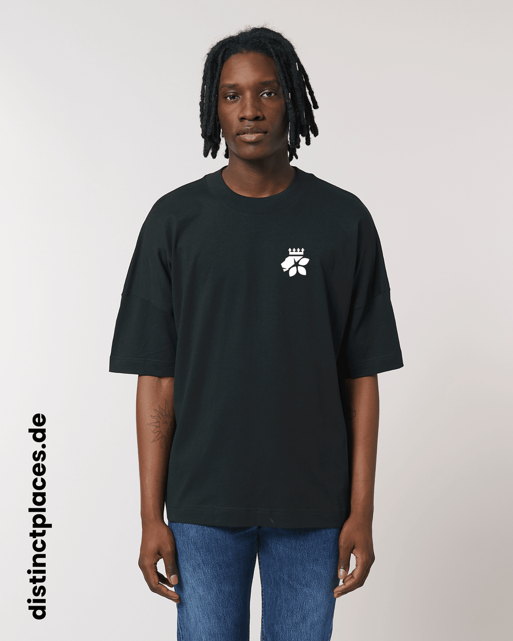 Mann von vorne trägt schwarzes fairtrade, vegan und bio-baumwoll T-Shirt mit einem minimalistischem weißen Logo, beziehungsweise Wappen für Saarbrücken