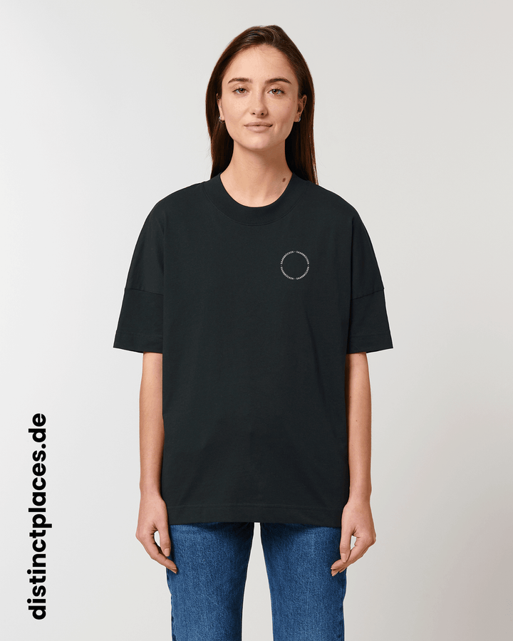 Frau von vorne trägt schwarzes fairtrade, vegan und bio-baumwoll T-Shirt mit einem minimalistischem weißen Logo, beziehungsweise Schriftzug für Saarbrücken