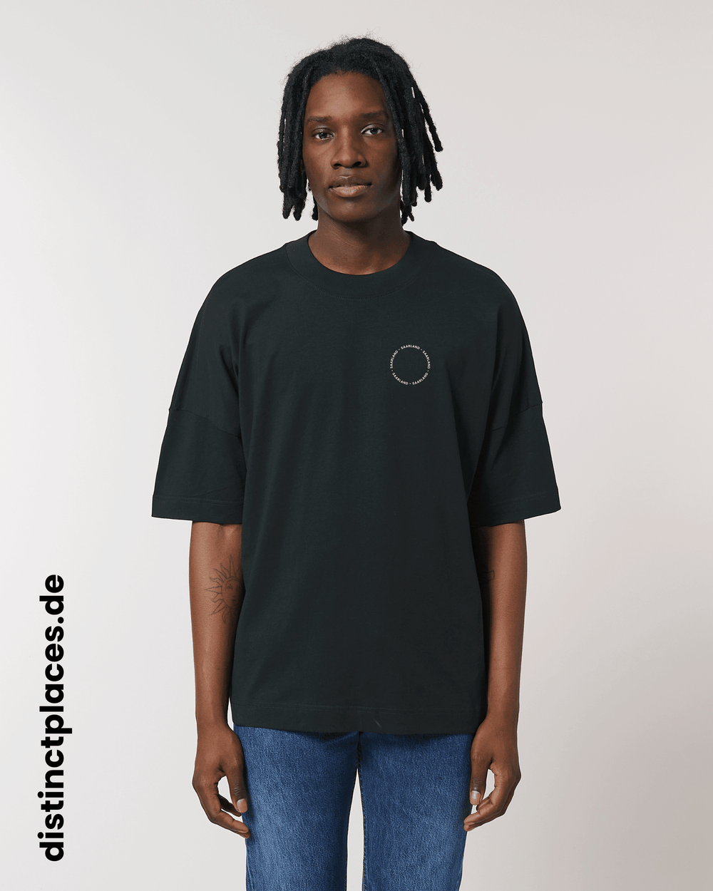 Mann von vorne trägt schwarzes fairtrade, vegan und bio-baumwoll T-Shirt mit einem minimalistischem weißen Logo, beziehungsweise Schriftzug für Saarland