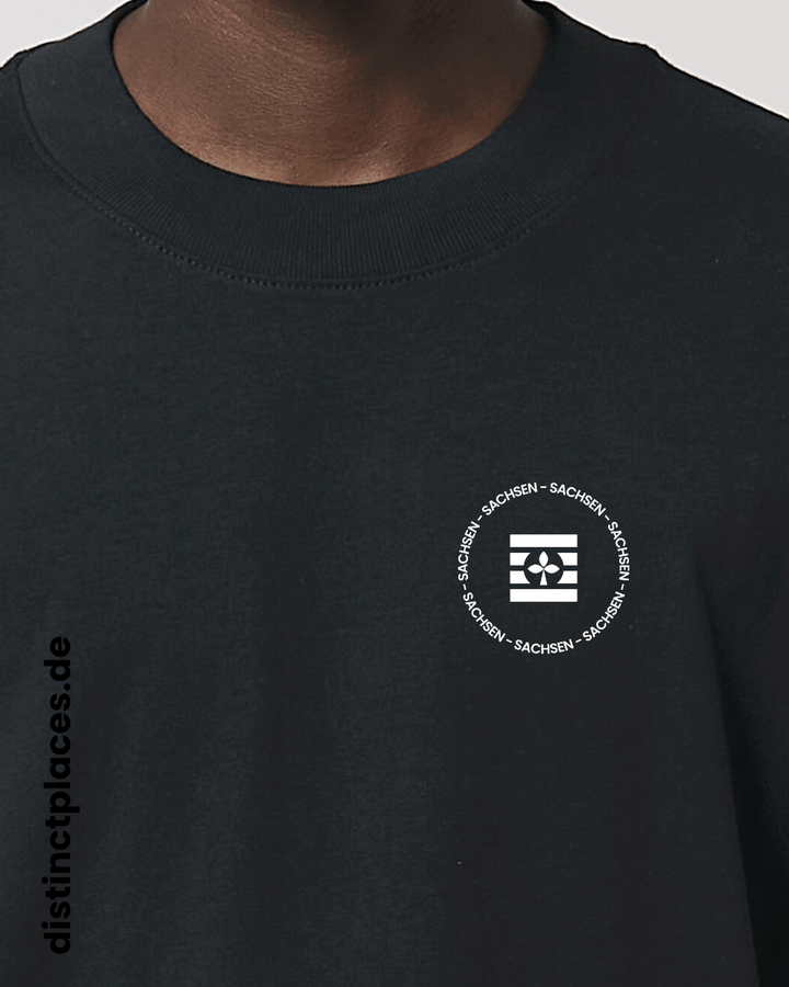 Detailansicht schwarzes fairtrade, vegan und bio-baumwoll Oversized T-Shirt von vorne mit einem minimalistischem weißen Logo, beziehungsweise Wappen und Schriftzug für Sachsen